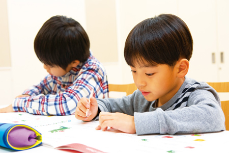 テキストに英語を書き込む小学生